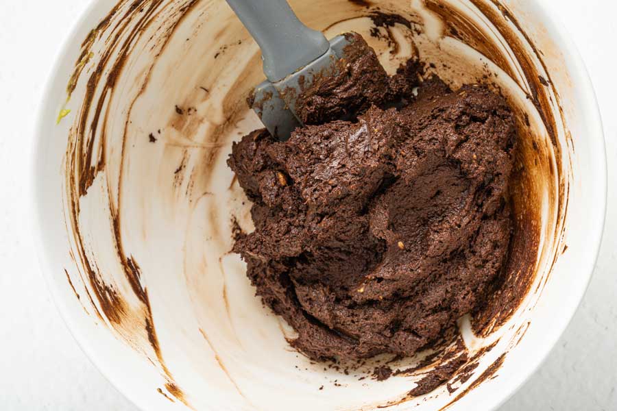 Avocado chocolate truffle batter in a white bowl is ready to go in the refrigerator for chilling.