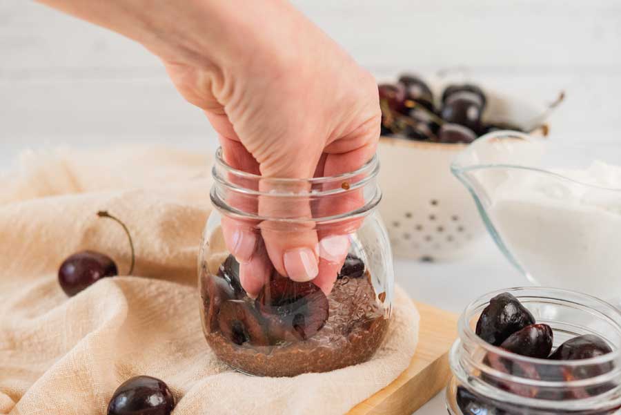 placing sliced cherries around a mason jar
