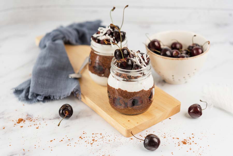 two mason jars with black forest chocolate chia pudding