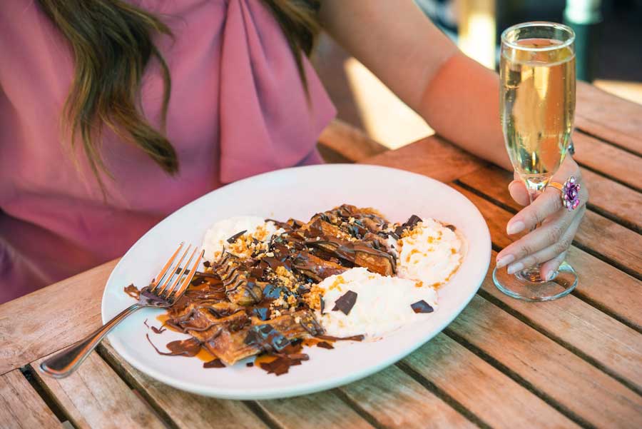 woman holdiong champagne with a nutella waffle