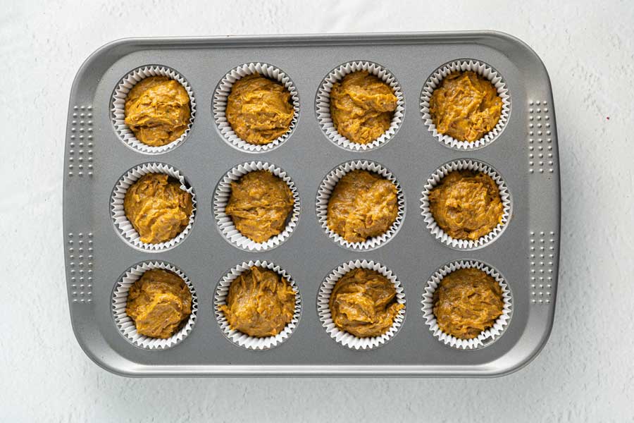 muffin batter divided evenly into paper liners in muffin tins.