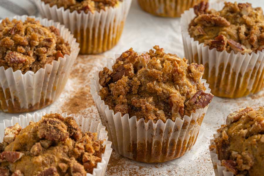 Close up image of pumpkin vegan muffins in paper muffin liners.