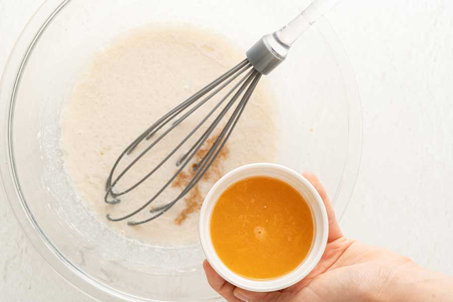Adding orange juice to make cake batter.