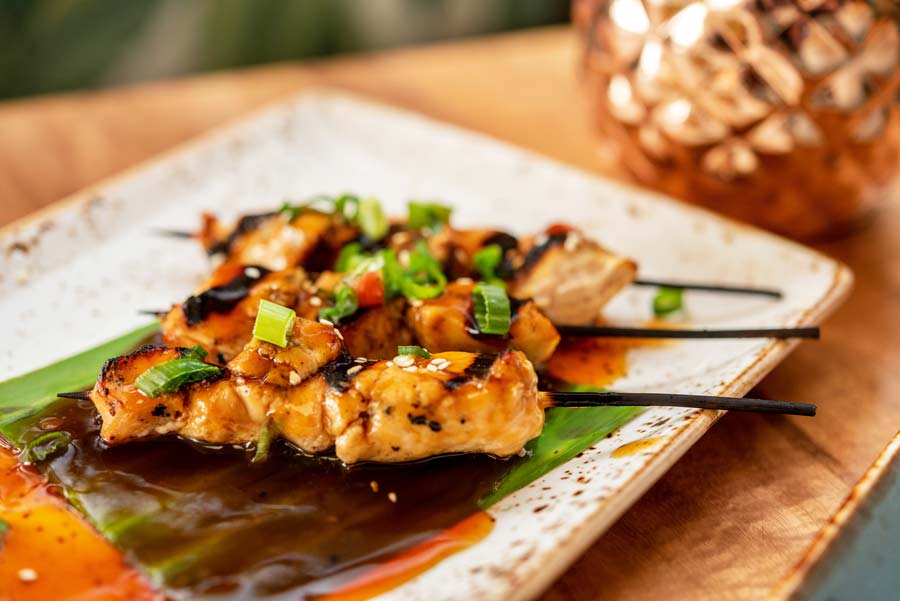 three chicken skewers with teriyaki sauce