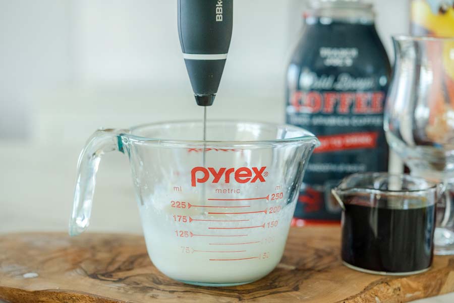 mixing sweet cream cheese topping with milk frother