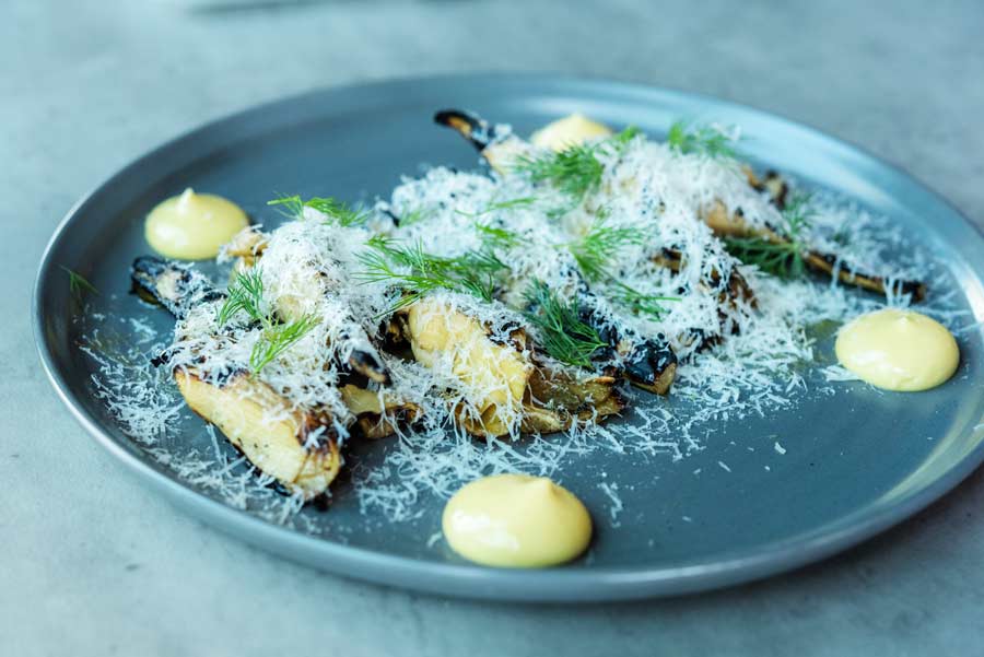 grilled artichokes with grated cheese on a table