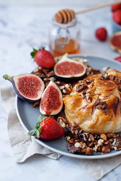 Baked-Brie-in-Puff-Pastry-on a plate with fogs and strawberries